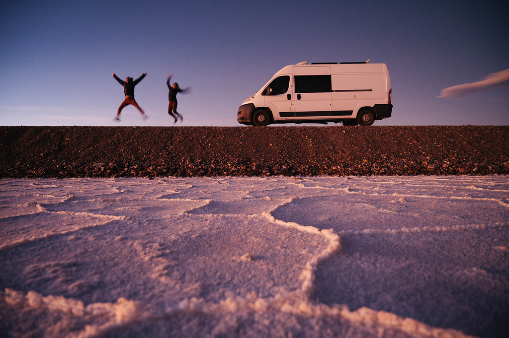 Maxine and Theo jumping in front of the van at sunset. Salinas Grandes salt flat, Jujuy Province - Argentina