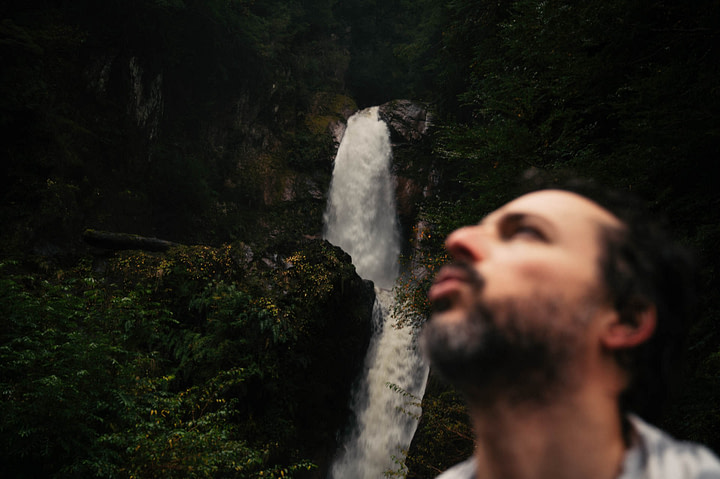 Theo huffing and puffing after a cold swim in front of a waterfall, surrounded by lush green. Cascada La Virgen, Chile