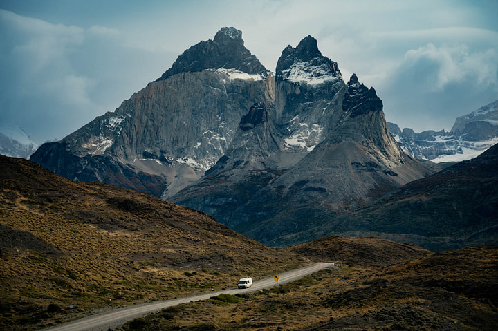 Campervan driving down a road before Cuernos del Paine in Torres del Paine National Park, Chile