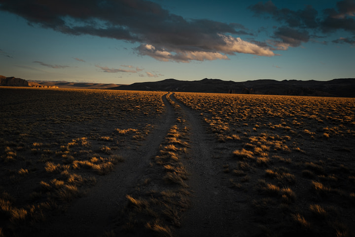 Dirt tracks leads to a stunning sunset on the heights of the Argentinean Estepa (Steppe) near Cueva de Las Manos. Santa Cruz Province - Argentina