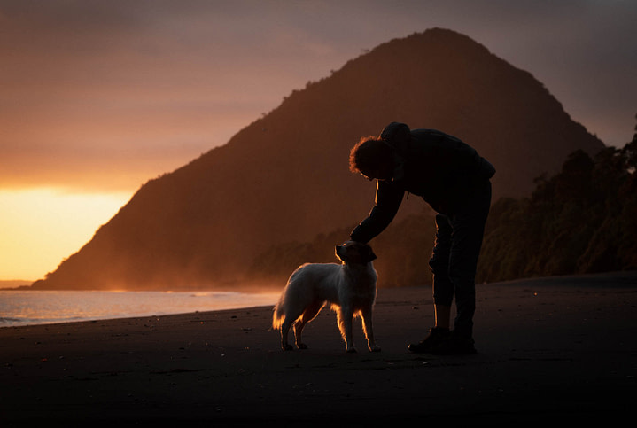 Theo at sunset in the black volacanic ash beach of Santa Barbara, petting a local dog. Chaitén, Chile.