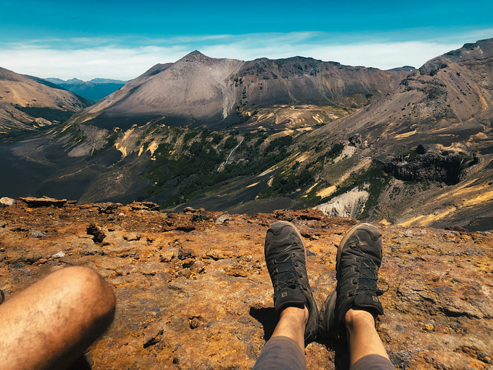 Our tired feet look over the landscape of Lanin National Park from the summit of Volcan Achen Ñiyeu. Looks ashy and grey like the moon. Northern Patagonia, Argentina.