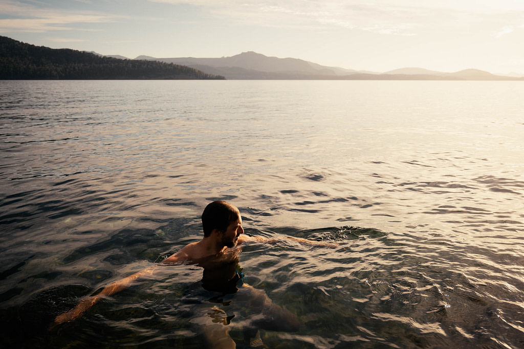 Theo swimming in a golden morning at Lake Nahuel Huapi. Bariloche, Río Negro - Argentina